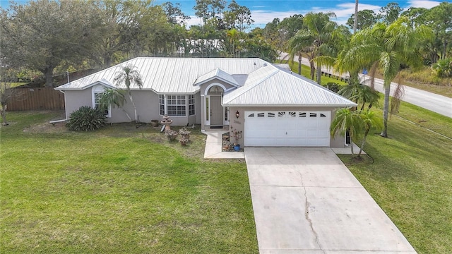 ranch-style house featuring concrete driveway, stucco siding, metal roof, an attached garage, and a front yard