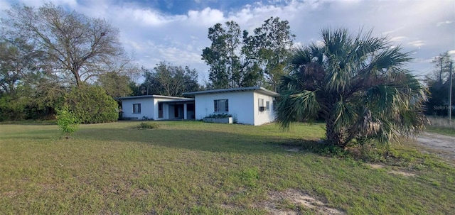 view of front of house featuring a front lawn and stucco siding