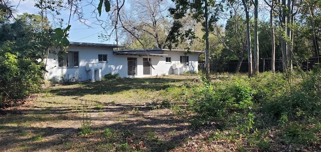 back of house featuring fence and stucco siding