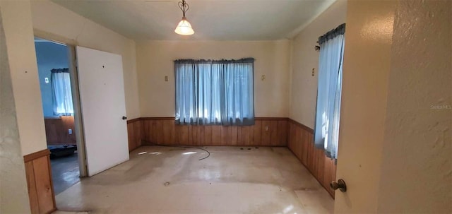 empty room with a wainscoted wall and wooden walls