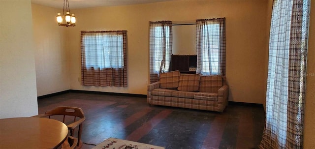 living area with an inviting chandelier, baseboards, and wood finished floors