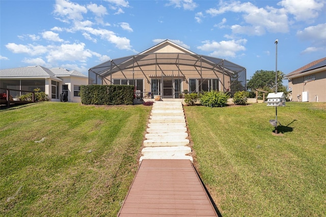 rear view of house featuring a lanai and a lawn