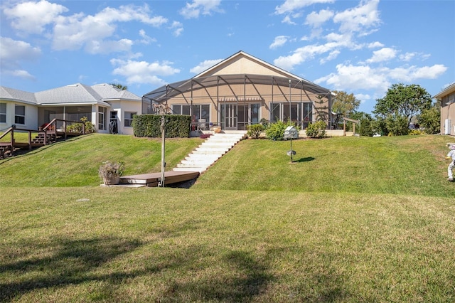 rear view of property with a lanai, a yard, and stairs