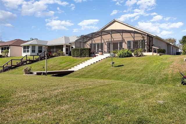 back of house featuring a lanai and a lawn