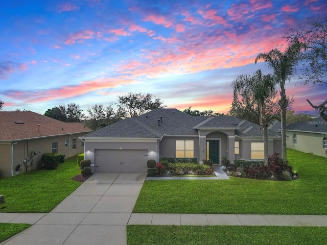 ranch-style house featuring a garage, a front yard, driveway, and stucco siding