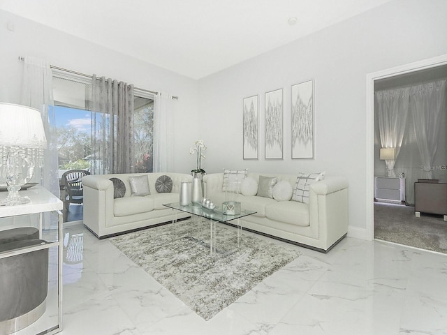 living area featuring marble finish floor and baseboards