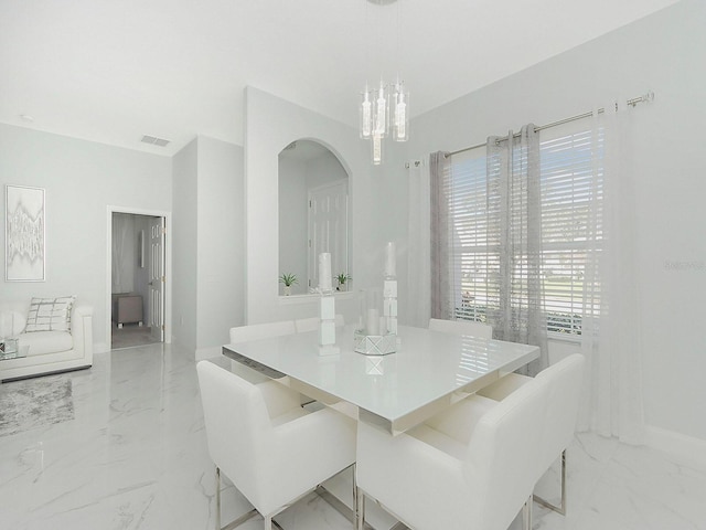 dining space featuring marble finish floor, baseboards, visible vents, and a notable chandelier