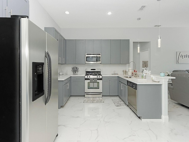 kitchen with a peninsula, a sink, marble finish floor, appliances with stainless steel finishes, and gray cabinets