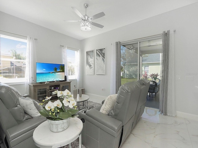 living room featuring marble finish floor, ceiling fan, and baseboards