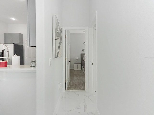 hall with marble finish floor and baseboards