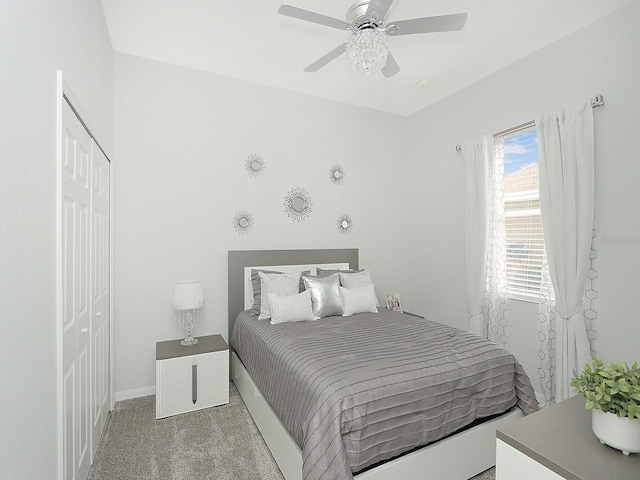 bedroom featuring a ceiling fan, a closet, light colored carpet, and baseboards