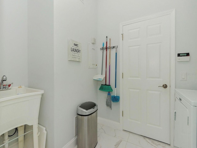 bathroom featuring marble finish floor, washer / dryer, and baseboards