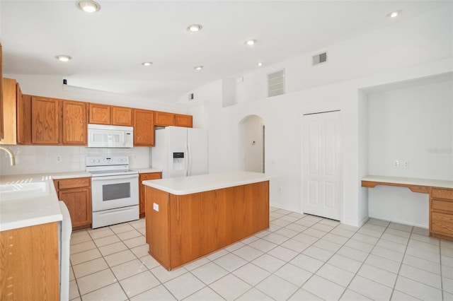 kitchen featuring a center island, white appliances, visible vents, and decorative backsplash