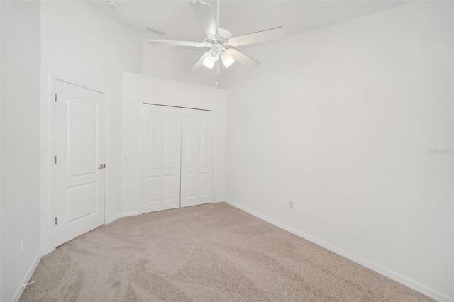 unfurnished bedroom featuring ceiling fan, a closet, carpet flooring, and baseboards