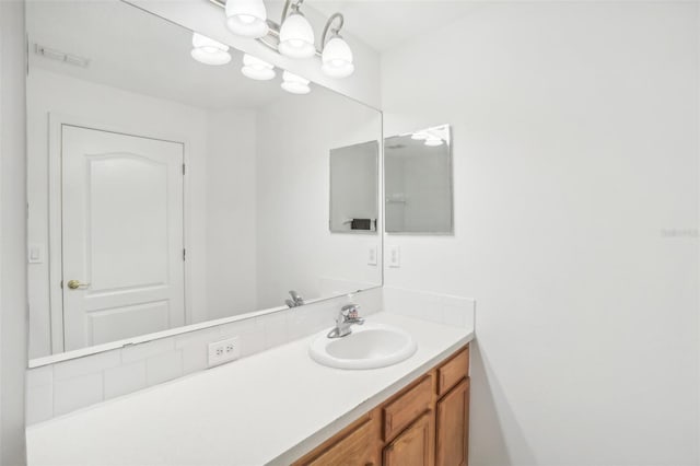 bathroom with visible vents, a notable chandelier, and vanity