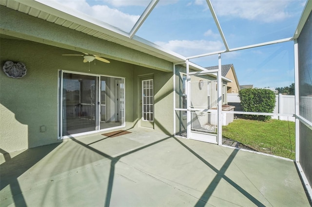 unfurnished sunroom with ceiling fan