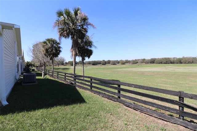 view of yard with a rural view, cooling unit, and fence