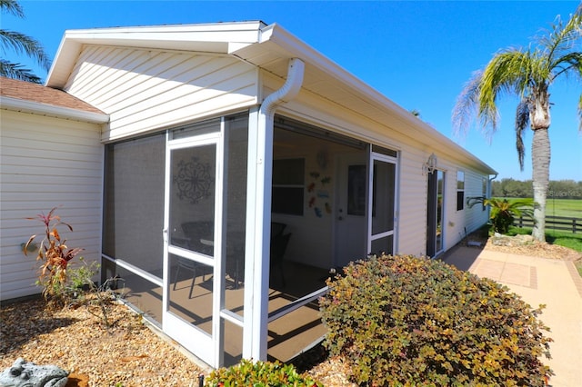 view of property exterior with a sunroom