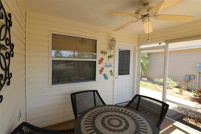 view of exterior entry with ceiling fan and outdoor dining space