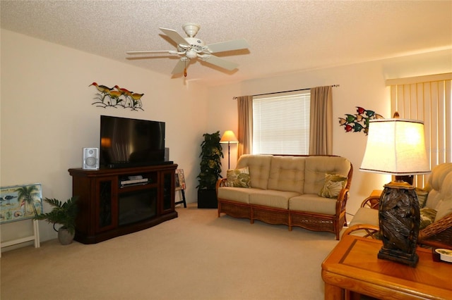 carpeted living area with a textured ceiling and a ceiling fan