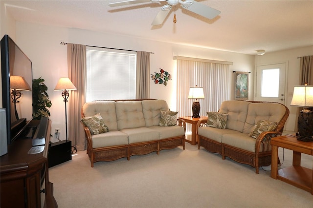 carpeted living area featuring a ceiling fan