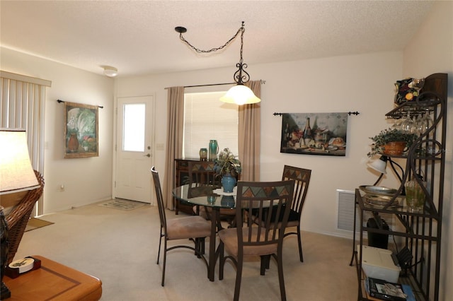 dining space with carpet floors and a textured ceiling