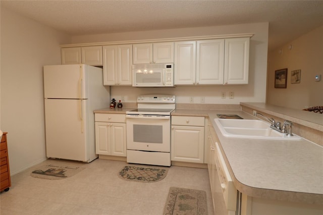 kitchen with white appliances, light countertops, a sink, and a peninsula