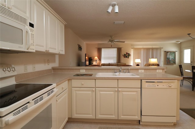 kitchen featuring open floor plan, a sink, ceiling fan, white appliances, and a peninsula