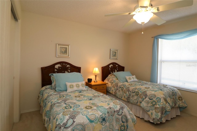 carpeted bedroom featuring baseboards and a ceiling fan