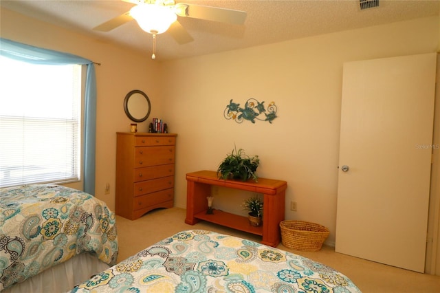 bedroom featuring carpet, ceiling fan, and a textured ceiling