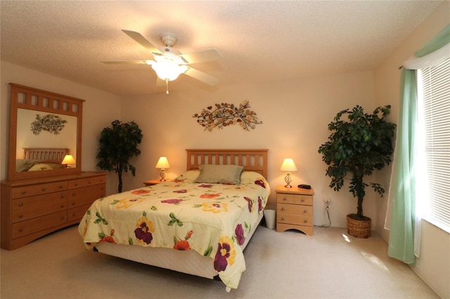 bedroom with carpet, ceiling fan, and a textured ceiling