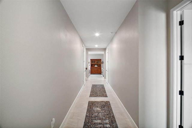 hallway with recessed lighting, baseboards, and light tile patterned floors