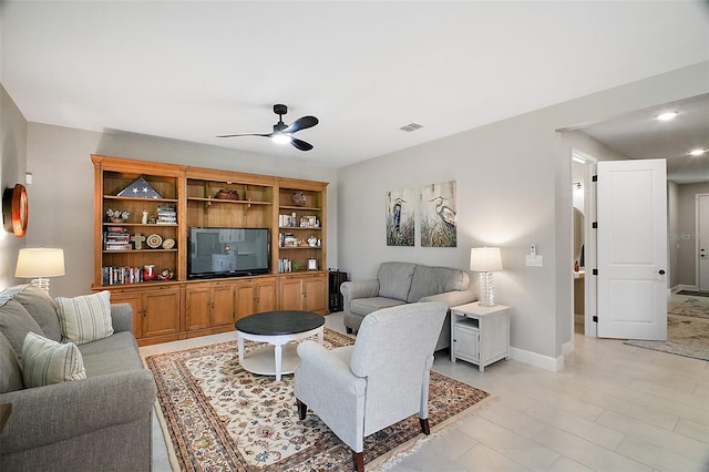 living room with ceiling fan, visible vents, and baseboards