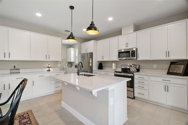 kitchen featuring visible vents, an island with sink, appliances with stainless steel finishes, light countertops, and a sink