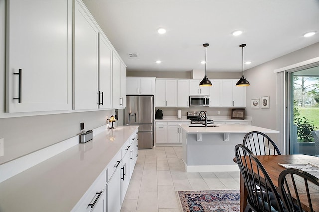 kitchen featuring stainless steel appliances, recessed lighting, light countertops, white cabinetry, and a sink