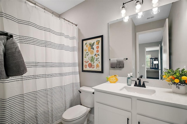 full bath featuring toilet, vanity, and visible vents