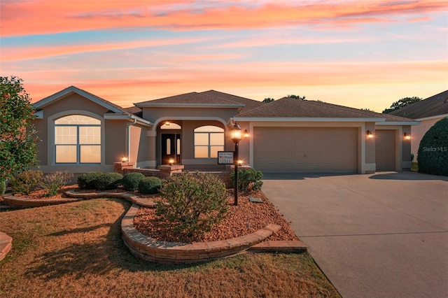 view of front facade featuring concrete driveway, a front lawn, an attached garage, and stucco siding