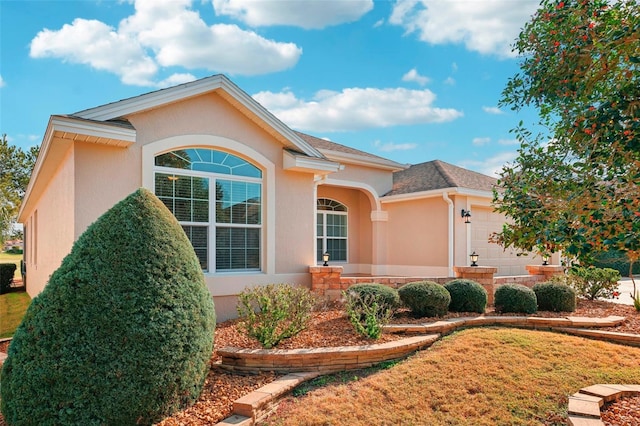 view of side of property with a garage, a shingled roof, and stucco siding