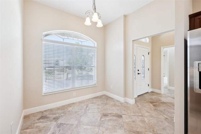 entrance foyer featuring a notable chandelier and baseboards