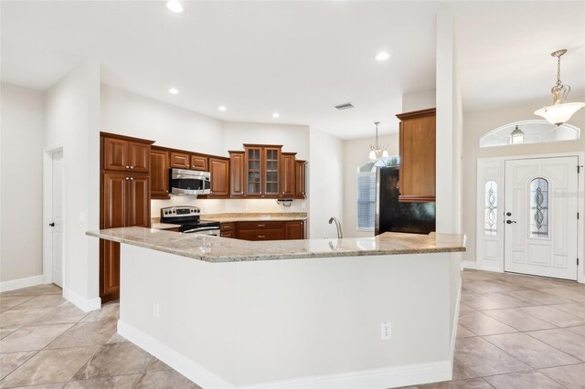 kitchen featuring light stone counters, stainless steel appliances, visible vents, hanging light fixtures, and brown cabinets