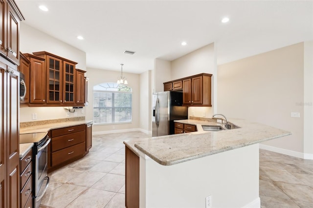 kitchen with light stone counters, visible vents, appliances with stainless steel finishes, a sink, and a peninsula