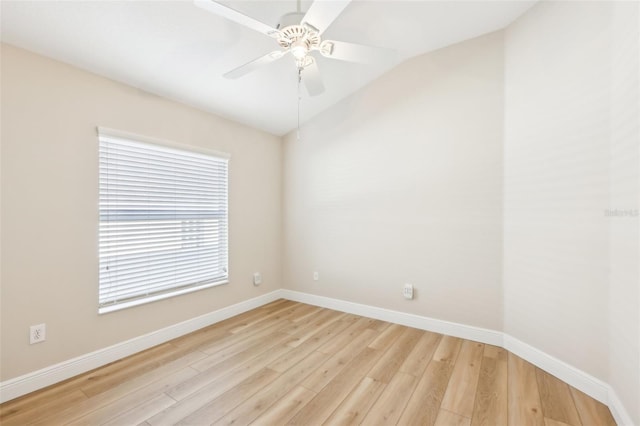 spare room featuring vaulted ceiling, a ceiling fan, light wood-style flooring, and baseboards