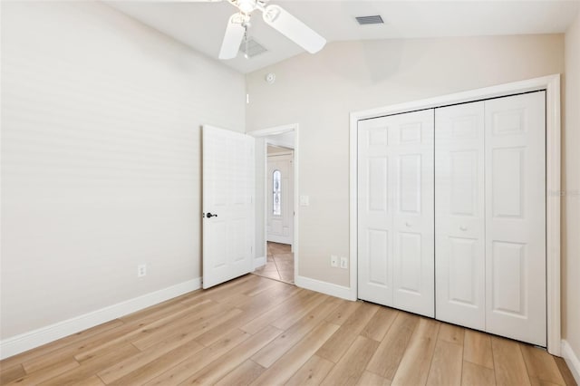 unfurnished bedroom with light wood finished floors, a closet, visible vents, vaulted ceiling, and baseboards