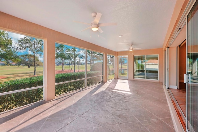 unfurnished sunroom featuring a ceiling fan