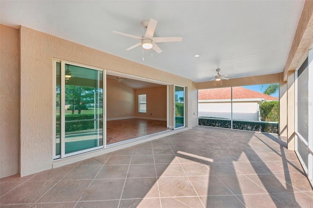 unfurnished sunroom with ceiling fan