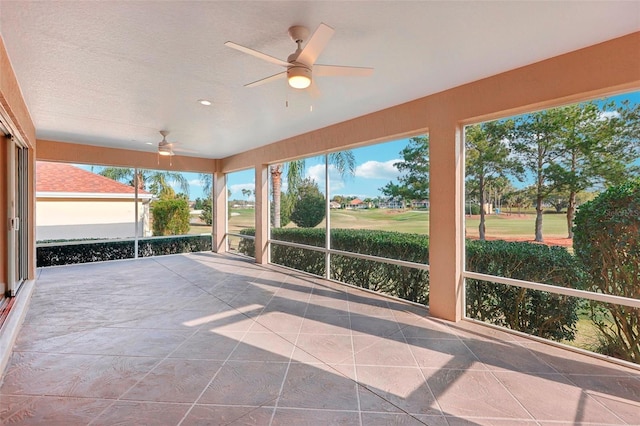 unfurnished sunroom featuring a ceiling fan