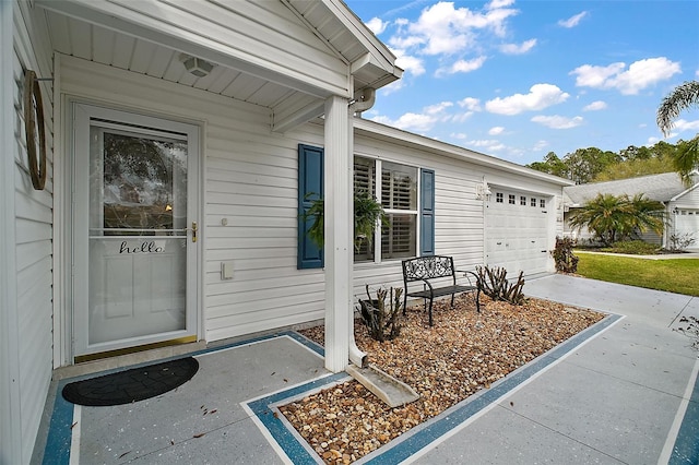 doorway to property with a garage and concrete driveway