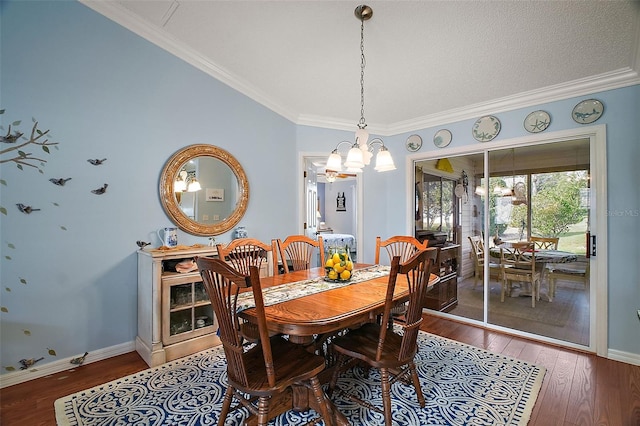 dining area featuring an inviting chandelier, crown molding, baseboards, and wood finished floors