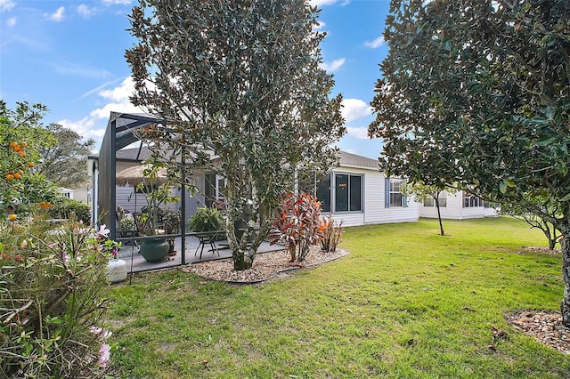 rear view of property featuring glass enclosure, a lawn, and a patio area