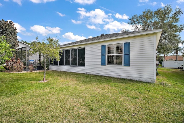 rear view of house with a sunroom and a yard